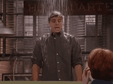 a man is standing under a shower with a sign in the background that says harry potter .