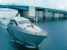 a boat is going under a bridge with a man on the deck