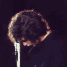 a man singing into a microphone with his hand on his mouth