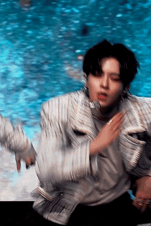 a blurry picture of a man dancing in front of a pool of water