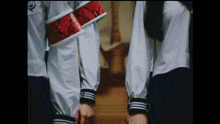 a person wearing a white shirt with a red band around their waist
