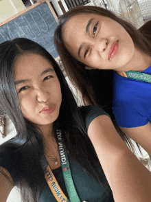two girls are posing for a picture and one has a lanyard that says iccgc