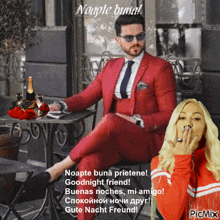 a man in a red suit sits at a table next to a woman in a red jacket