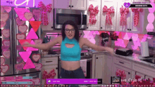 a woman dancing in a kitchen with hearts on the wall