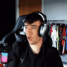 a young man wearing headphones is sitting in a chair .