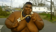 a very fat man wearing a gold chain and a cross .