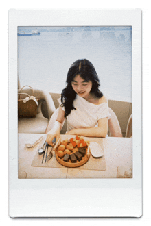 a woman is sitting at a table with a plate of food