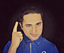 a man wearing a blue shirt with the letter c on the front