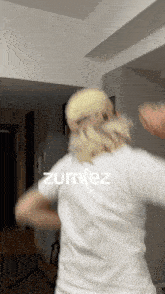 a person wearing a white shirt with zurniez written on the back
