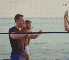 a man and woman give each other a high five on a beach