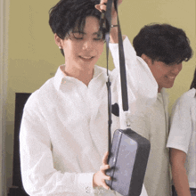 a man in a white shirt is holding a black bag with the word elyn on it