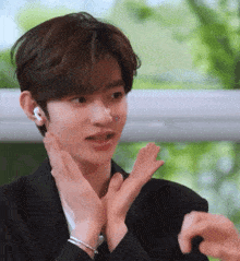 a young man with a sticker on his nose is clapping his hands together