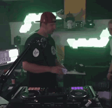 two men are standing in front of a dj mixer and one is holding a microphone ..
