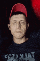 a man wearing a red hat and a black shirt that says " do n't worry "