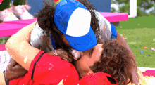 a man wearing a blue hat is kissing another man