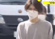 a man wearing a face mask and glasses is walking down the street .