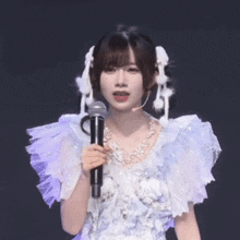 a woman in a white dress holds a microphone