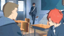 a man with red hair is standing in a classroom with other students