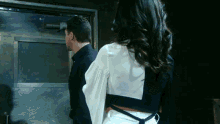 a man and a woman standing next to each other in front of a door
