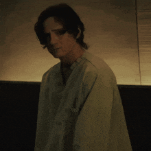a man in a green shirt is standing in the dark