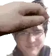 a hand is holding a man 's forehead in a pixel art .