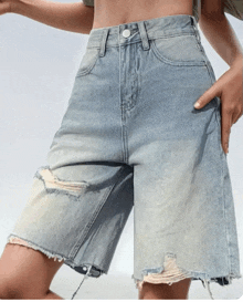 a woman wearing a pair of ripped shorts