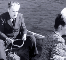 a man in a suit is pulling a rope while a woman looks on