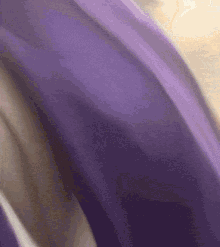 a close up of a purple cloth with a white border