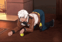 a man is kneeling on the floor holding a tennis ball .