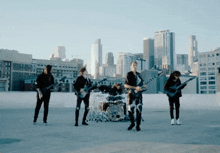 a group of men playing guitars and drums in front of a city skyline