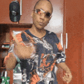 a man wearing sunglasses and a shirt with a dragon on it is giving a thumbs up