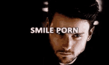 a close up of a man 's face with the words `` smile porn '' written on his eyes .