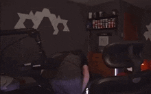a person laying on a bed in a dark room next to a chair
