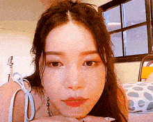 a close up of a woman 's face with a guitar in the background .