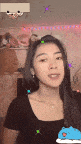 a girl with a cartoon face on her head looks at the camera