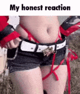 a woman in a costume with a belt around her waist is standing in the grass .