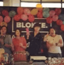 a group of people are posing for a picture in front of a sign that says blok e.