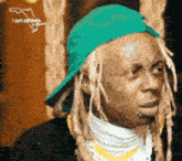 a man with dreadlocks wearing a green hat that says i am alright