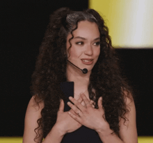 a woman with curly hair is wearing a headset