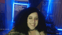 a woman smiles in front of a happy halloween sign