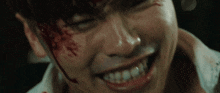 a close up of a man with blood on his face smiling