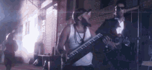 a man playing a keyboard and another man playing a guitar