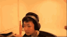 a man wearing headphones is sitting at a desk in front of a computer .