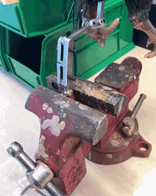 a red vise with a piece of metal sitting on top of it