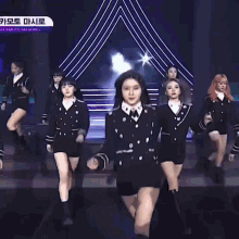 a group of young women are dancing on a stage in front of a purple background .