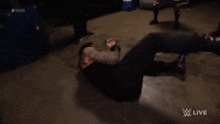 a wrestler laying on the ground with the word raw on the bottom right