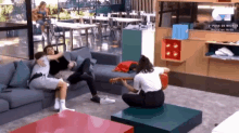 a woman is playing a guitar in a living room with people sitting on couches