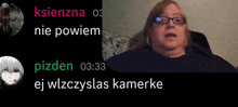 a woman with glasses sits on a couch next to a screen that says pizden