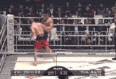two men in a boxing ring with a scoreboard that says 1:24