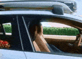 a white car with a surfboard on the roof and the word waymo on the side